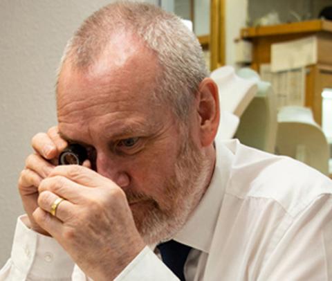 Valuer looking through a loupe